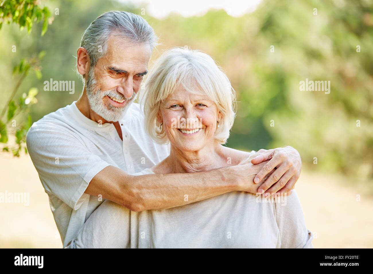 Les aînés heureux en amour hugging en été dans la nature Banque D'Images