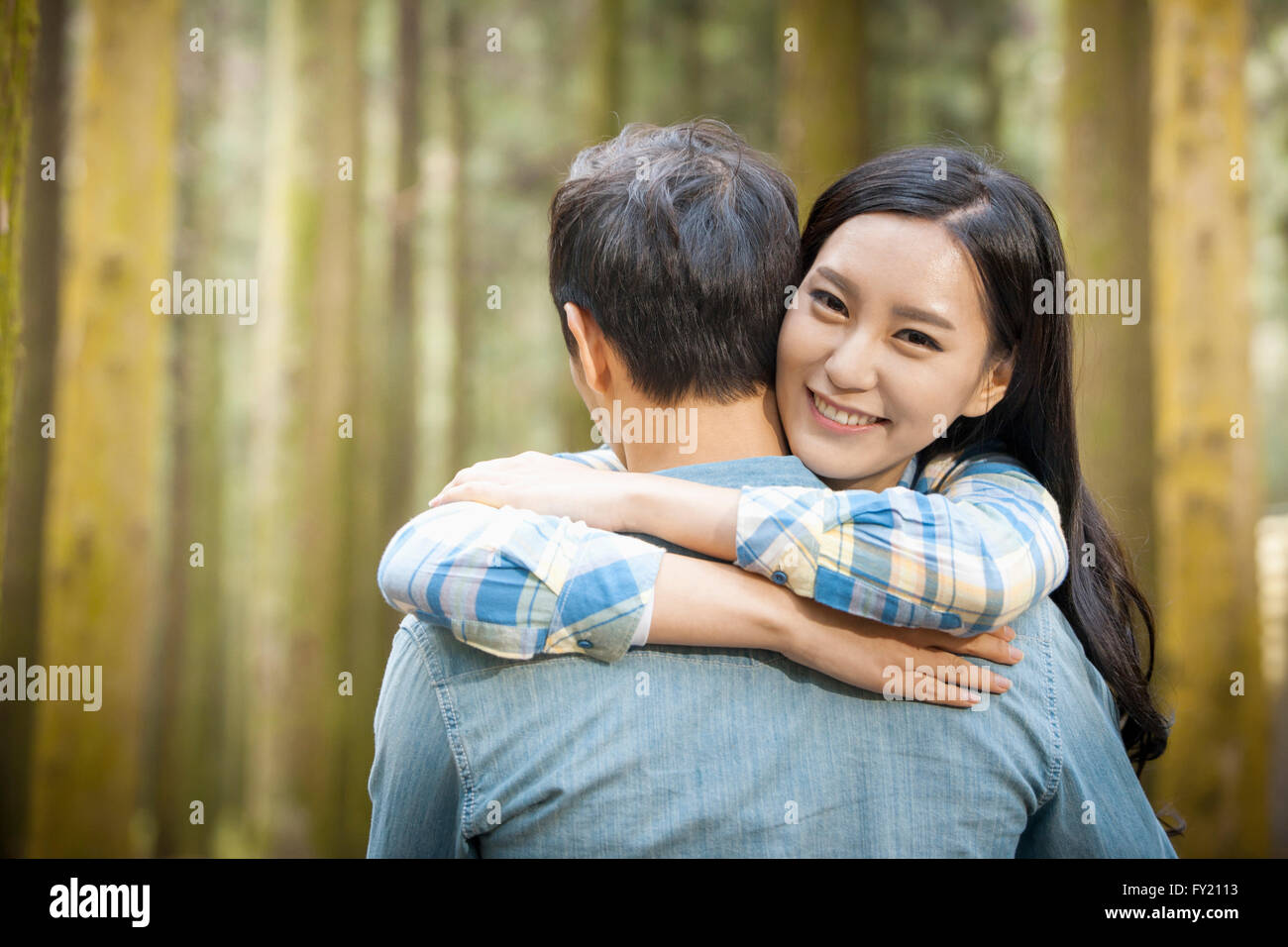Woman hugging her boyfriend and smiling Banque D'Images