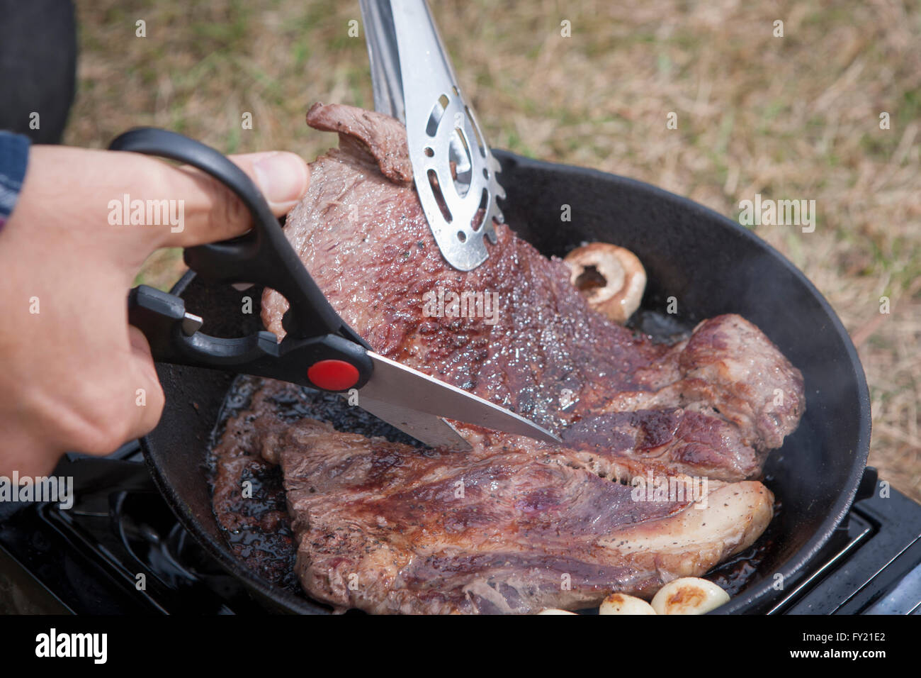 Steak d'être cuits et coupés par une personne Banque D'Images