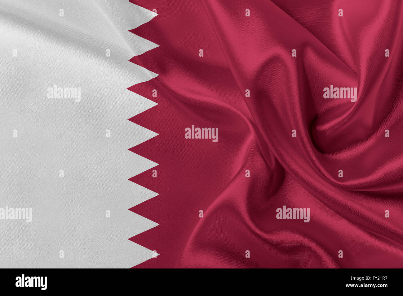 Brandissant le drapeau du Qatar dans le vent. Banque D'Images