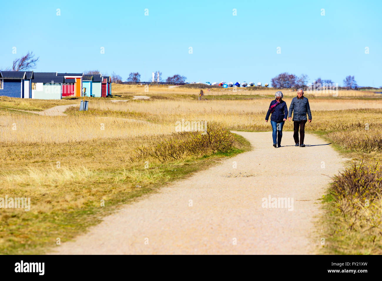 Skanor, Suède - 11 Avril 2016 : sont dehors pour une promenade sur le sentier de randonnée par la plage face par beaucoup de de cabines Banque D'Images Skanor, Suède - 11 Avril 2016 : sont dehors pour une promenade sur le sentier de randonnée par la plage face par beaucoup de de cabines Banque D'Images
