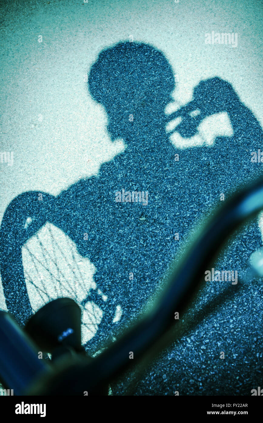 Ombre de man riding a bicycle on street Banque D'Images