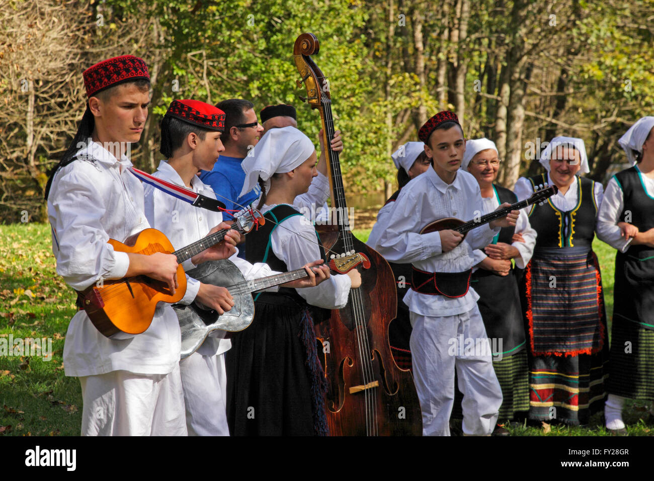 Personnes jouant instruments folkloriques habille en costume traditionnel sur les lacs de Plitvice en Croatie Banque D'Images