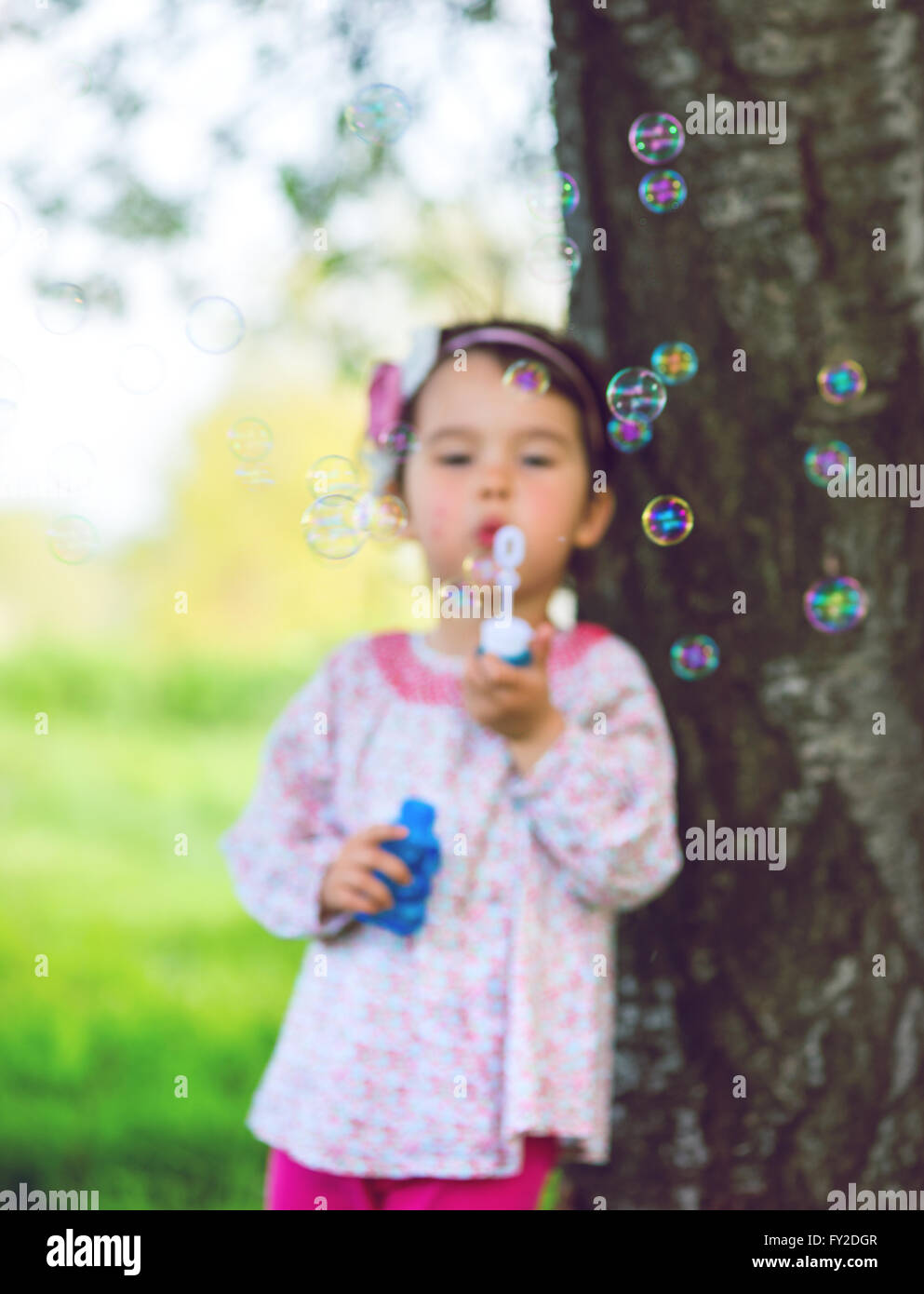 Portrait de funny jolie petite fille soufflant des bulles de savon Banque D'Images