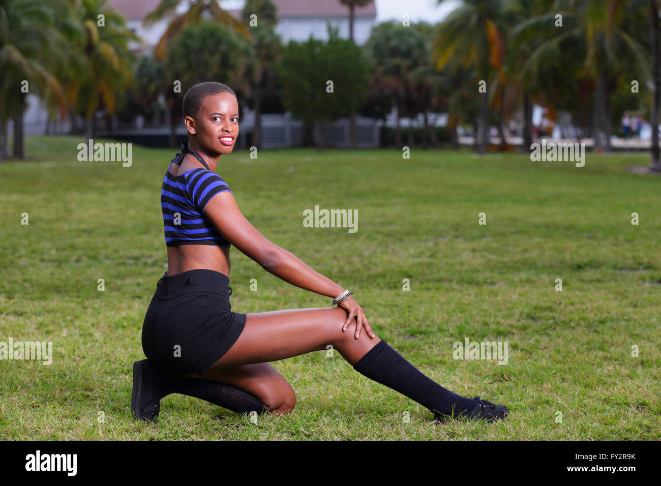 Dame posant sur un champ avec jambe tendus Banque D'Images