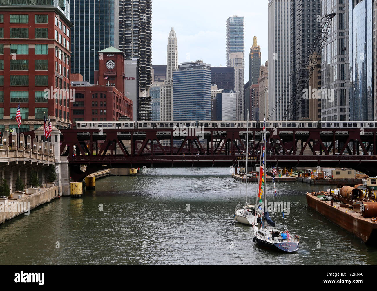 Voiliers d'attendre un train surélevé CTA pour effacer le Wells Street Bridge comme ils font leur chemin jusqu'à la rivière Chicago à Chicago Banque D'Images