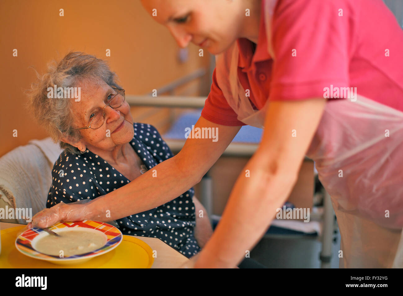 Femme, 89 ans, à l'heure du déjeuner, avec l'infirmière, maison de soins infirmiers Banque D'Images