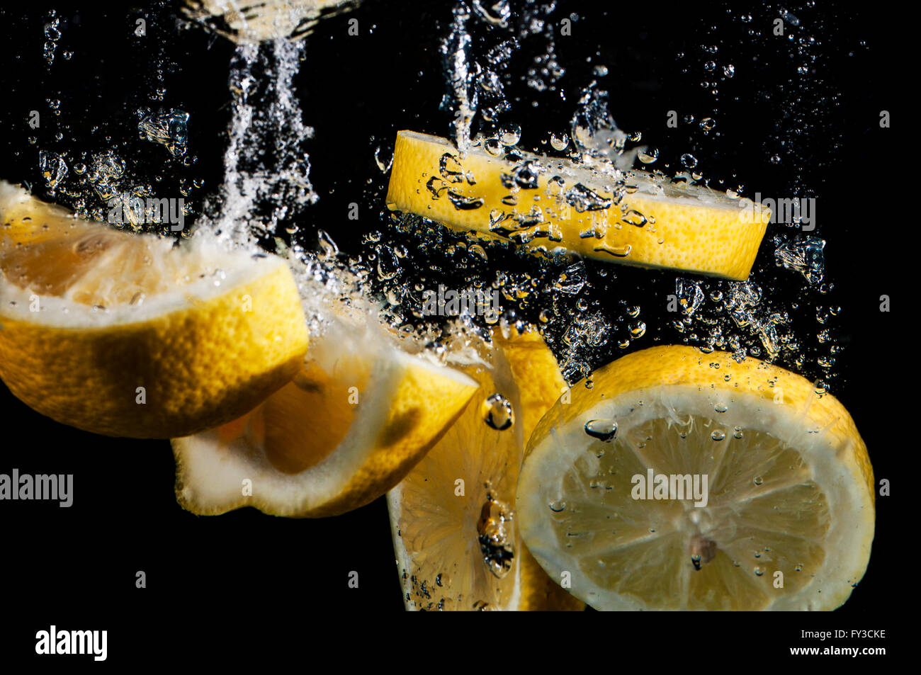Tranches de citron frais aux projections d'eau avec des bulles Banque D'Images