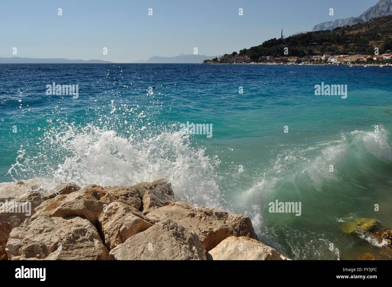 Les vagues sur une plage magnifique avec des pierres à podgora. en arrière-plan avec vue sur la montagne BIOKOVO et monument du seagull ailes. Croatie Banque D'Images