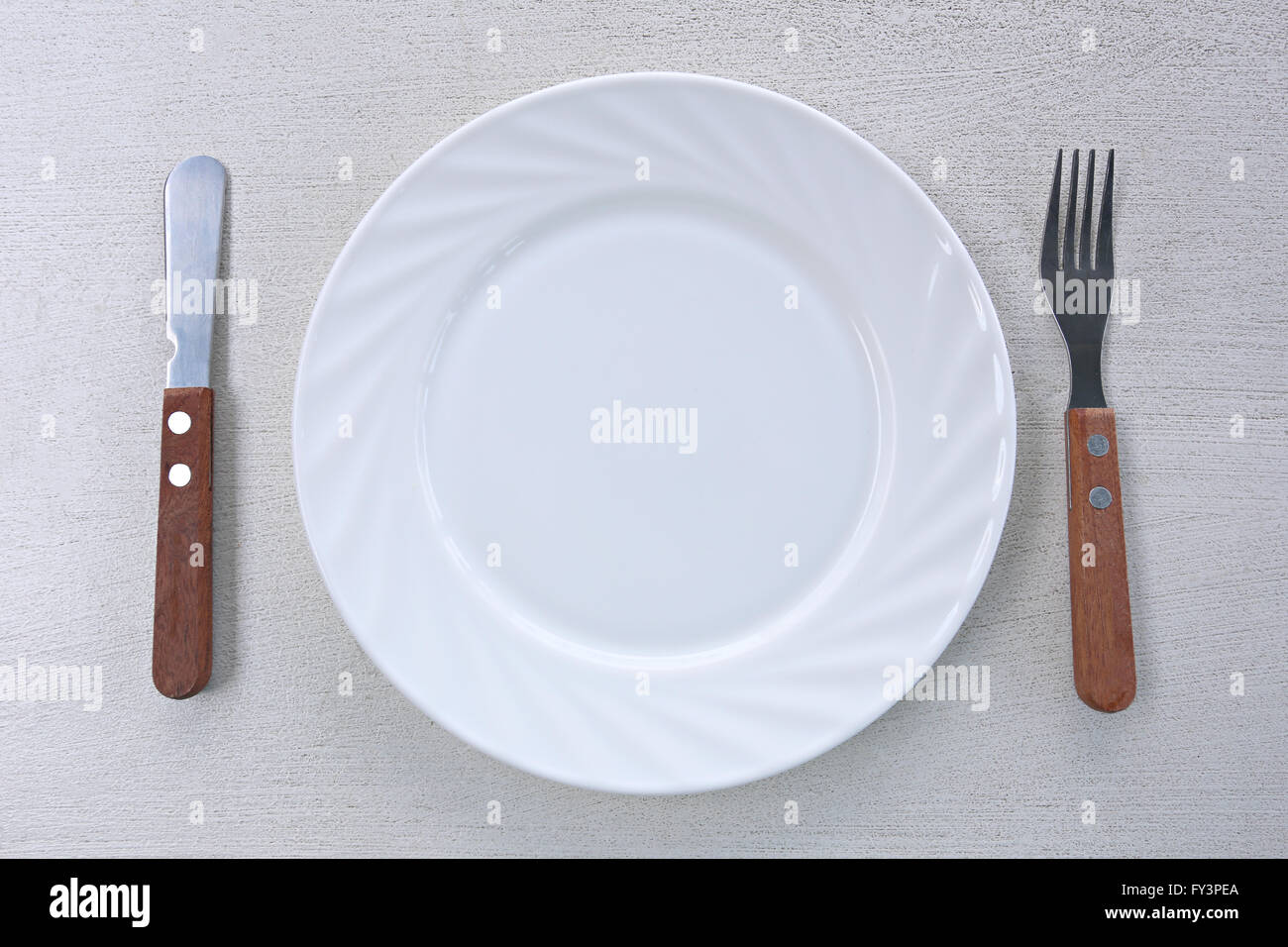 Plat blanc avec un couteau et fourchette est placé sur la table. Banque D'Images