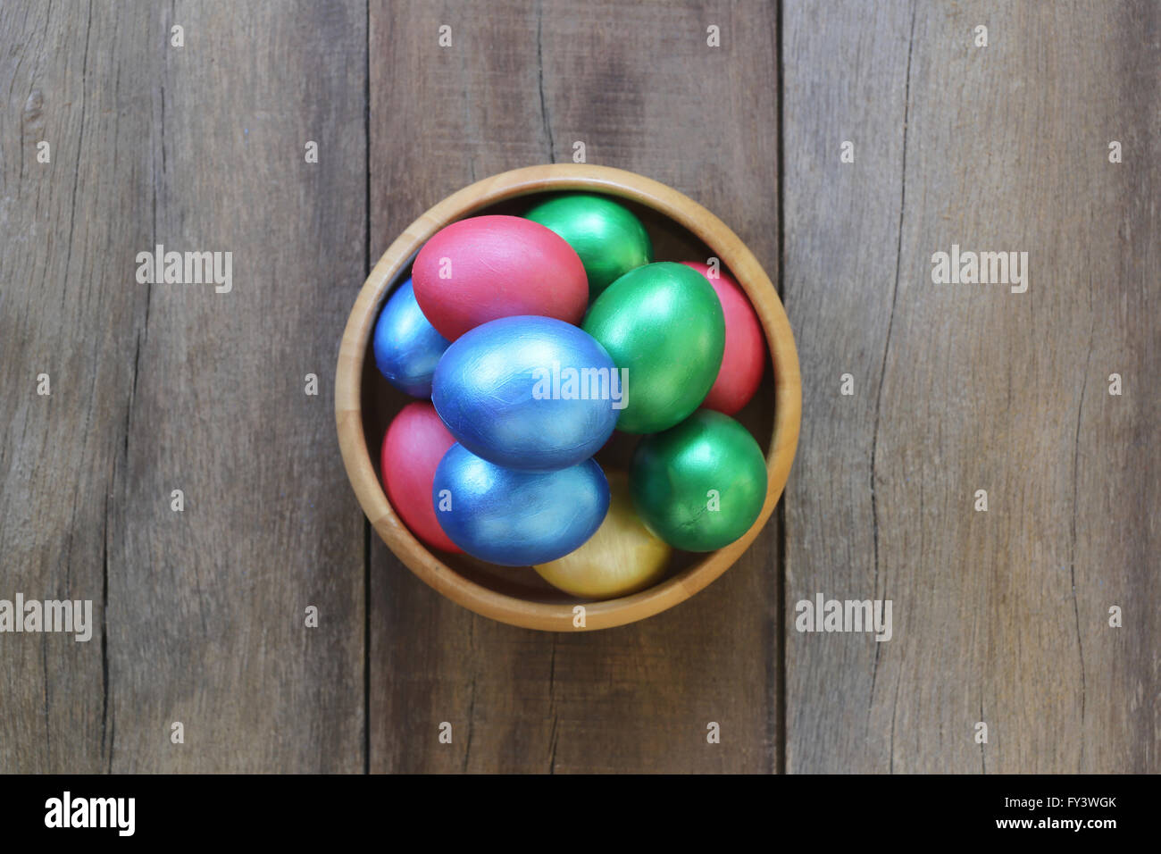 Œuf de Pâques une variété de couleurs dans bol en bois sur fond sombre. Banque D'Images
