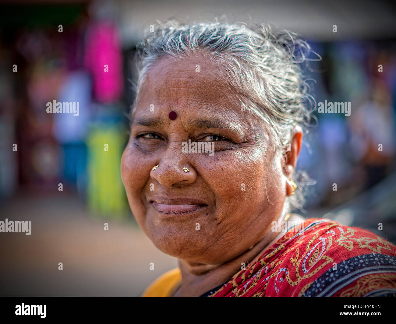 Dame indienne en marchant le long de la route de Kuilapalayam regarde la caméra et sourit Banque D'Images