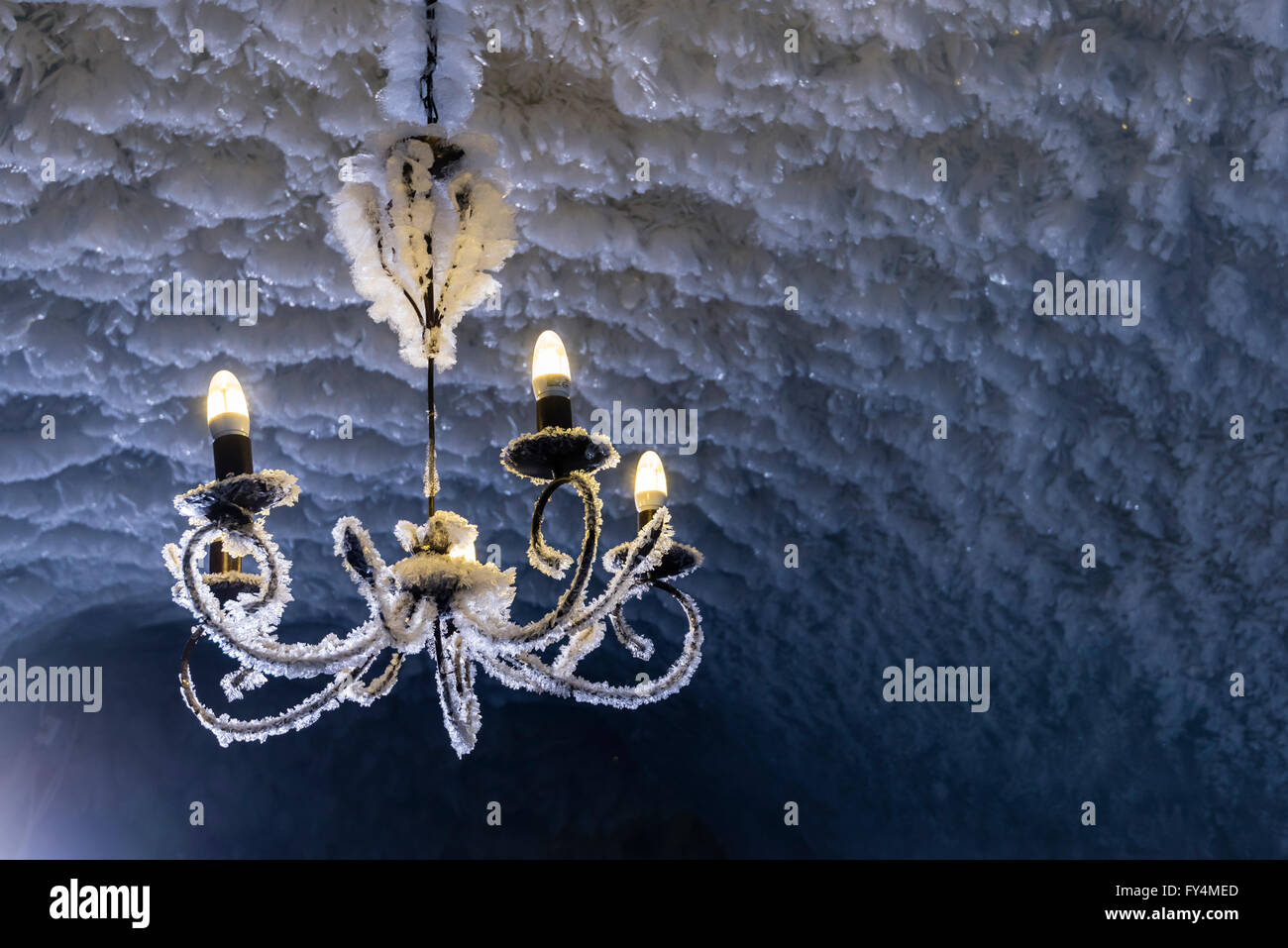 Un lustre en verre dépoli est accroché sur le plafond d'une grotte de glace Banque D'Images