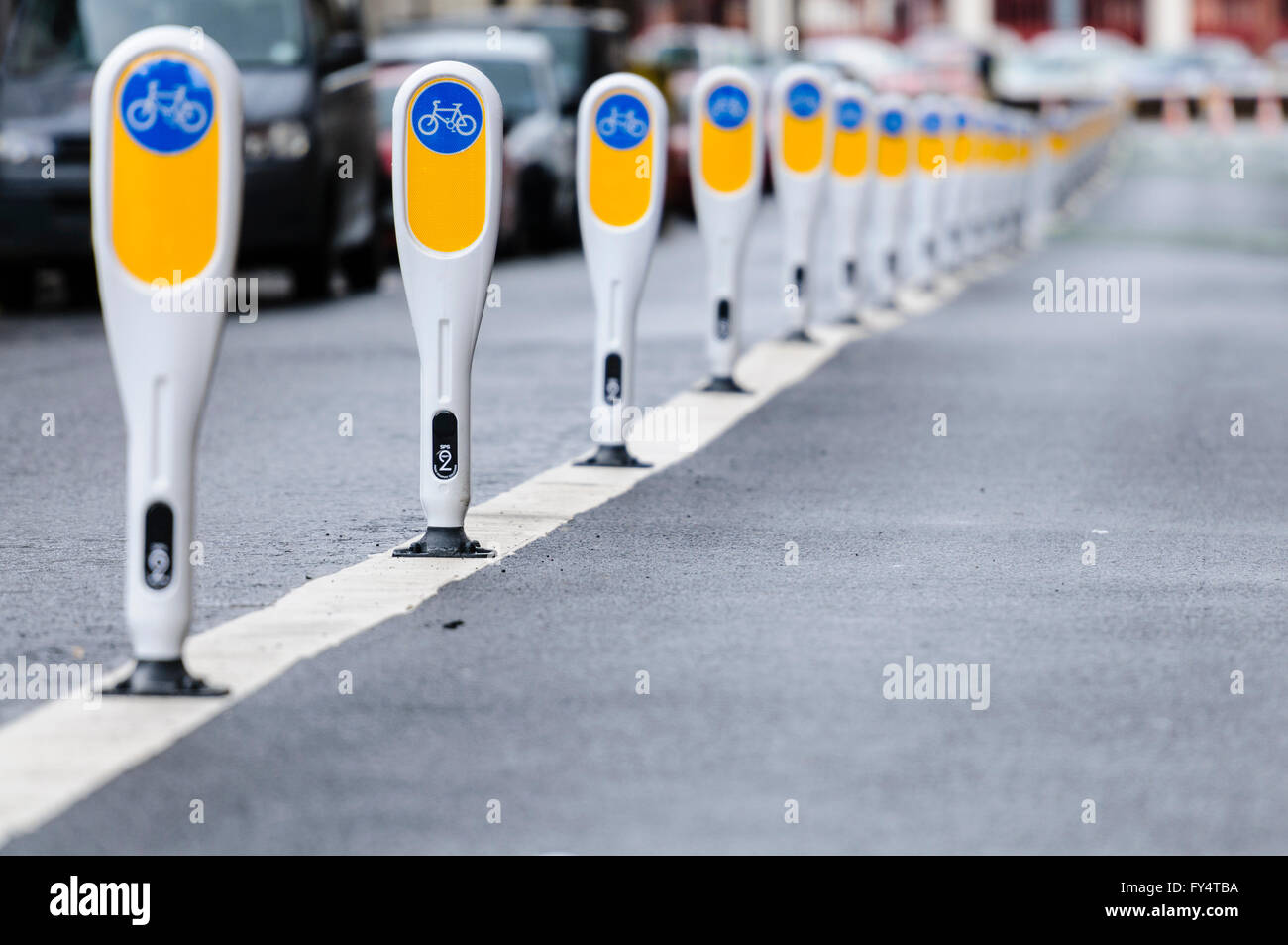 Rangée de bornes séparant une voie cyclable à partir de véhicules à moteur. Banque D'Images