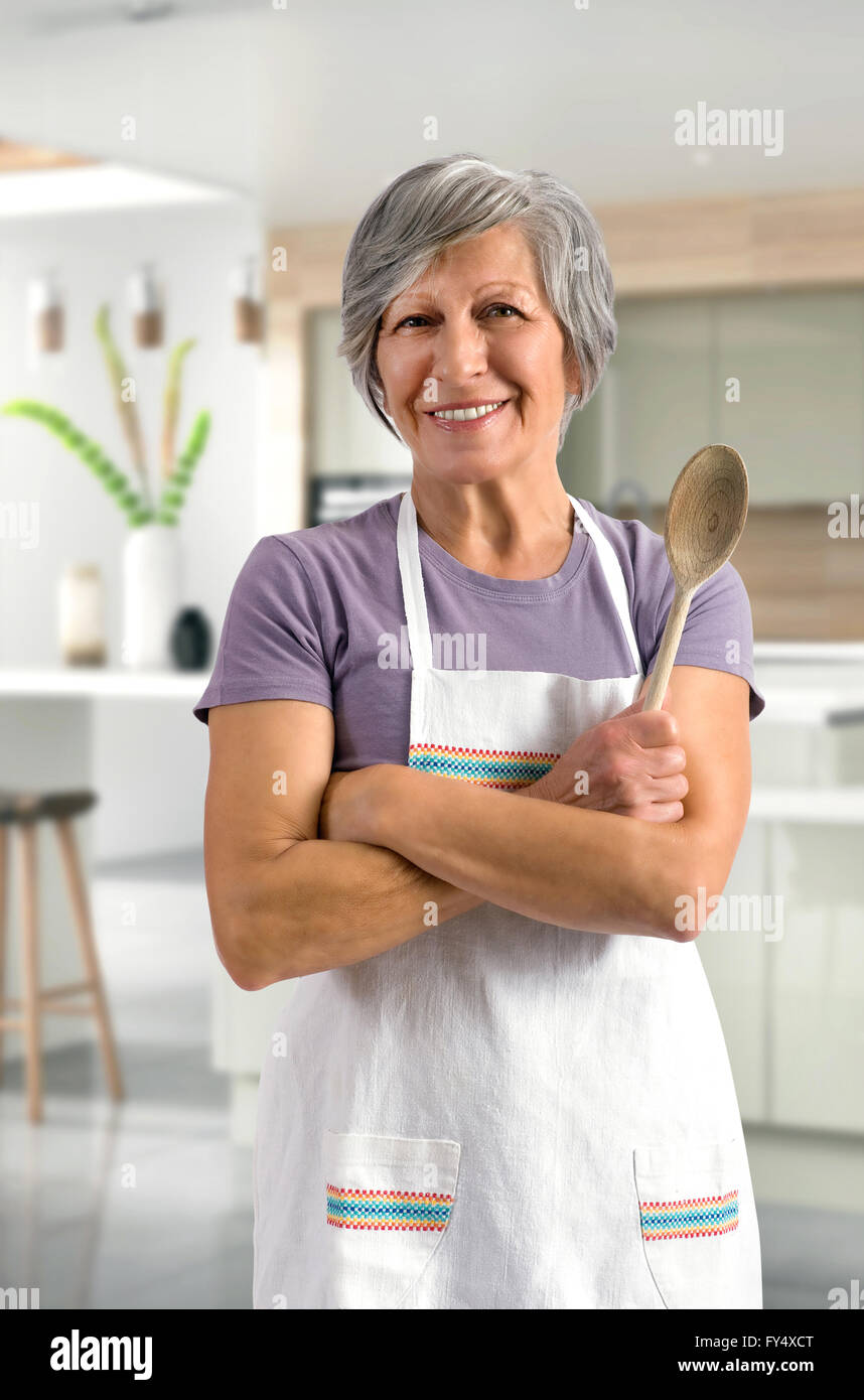 Happy friendly senior woman ou Granny la cuisson dans la cuisine Banque D'Images