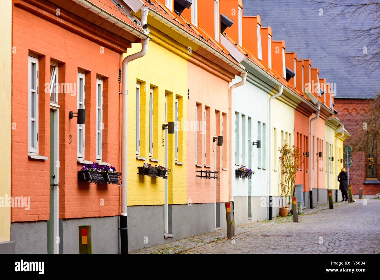 Trelleborg, Suède - 12 Avril 2016 : rangée de maisons peintes pastel près de l'église en arrière-plan. Une personne visible à t Banque D'Images
