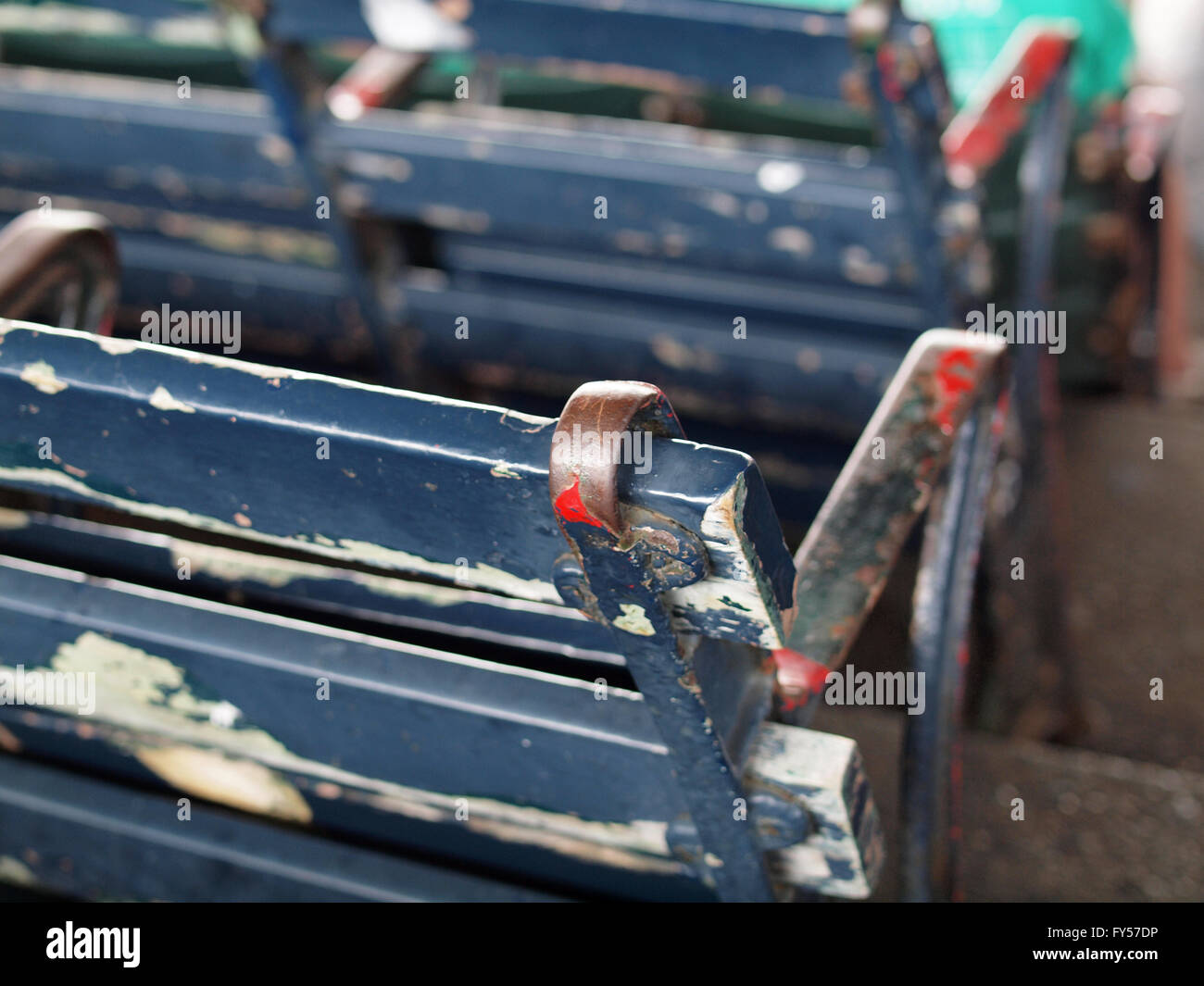 Old Baseball park siège avec chipping avec peinture bleu blanc et rouge dessous commençant à être révélé dans Fenway Park. Banque D'Images