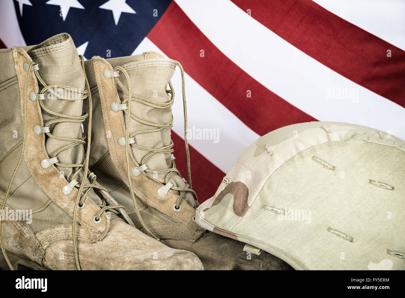 Vieilles chaussures de combat et le casque avec le drapeau américain en arrière-plan Banque D'Images