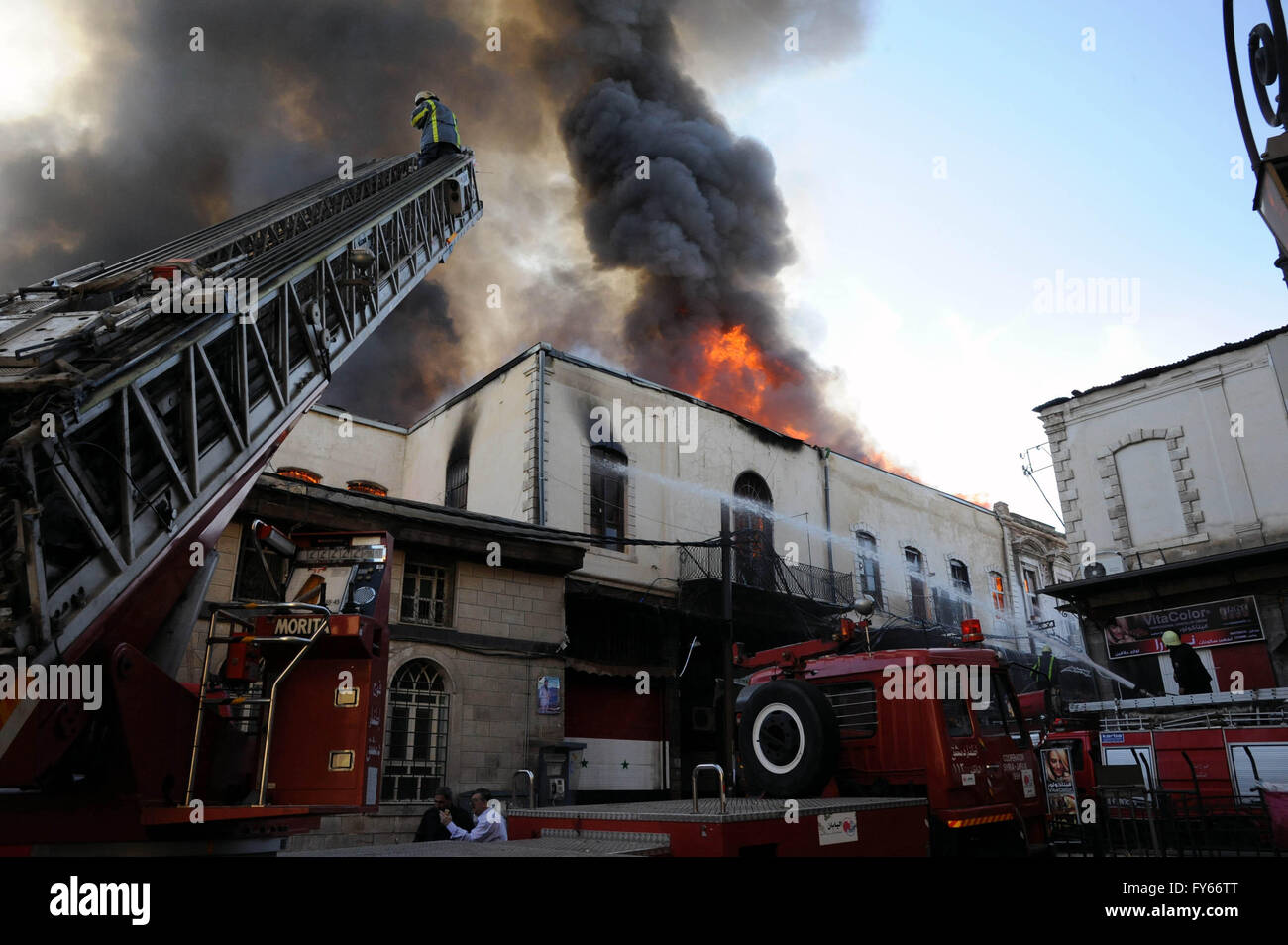 Damas, Syrie. Apr 23, 2016. Un immense panache de fumée et d'incendie se lever sur l'ancien marché d'Al-Assroniyah marché, ce qui est situé entre le centre historique et la célèbre citadelle Al-Hamidiyah Souk dans la vieille ville de Damas, capitale de la Syrie, le 23 avril 2016. Un grand incendie a éclaté en Al-Assroniyah tôt samedi, causant d'énormes pertes de biens. Deux rapports, l'incendie a été causé par un court-circuit. Credit : Ammar/Xinhua/Alamy Live News Banque D'Images