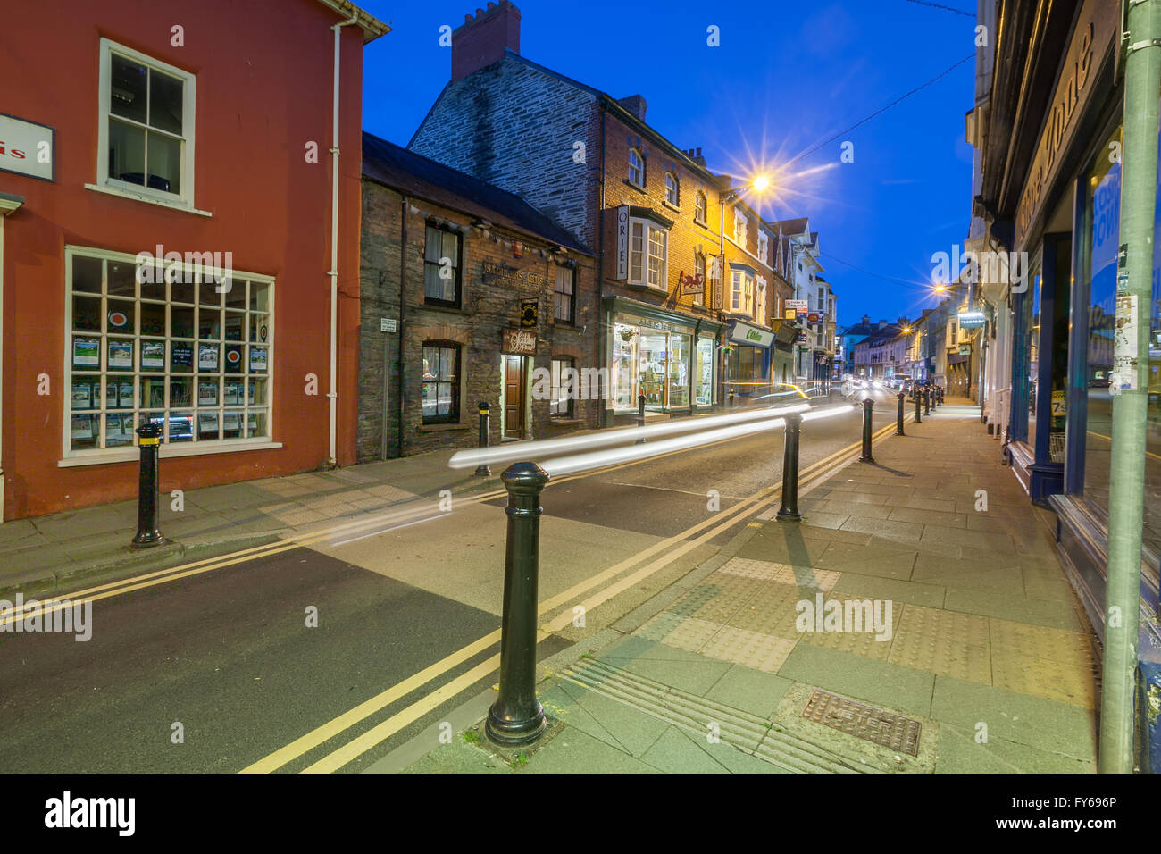 Cardigan High Street dans Ceredigion, pays de Galles. Prises au crépuscule avec des stries de lumière sentiers du trafic. Banque D'Images