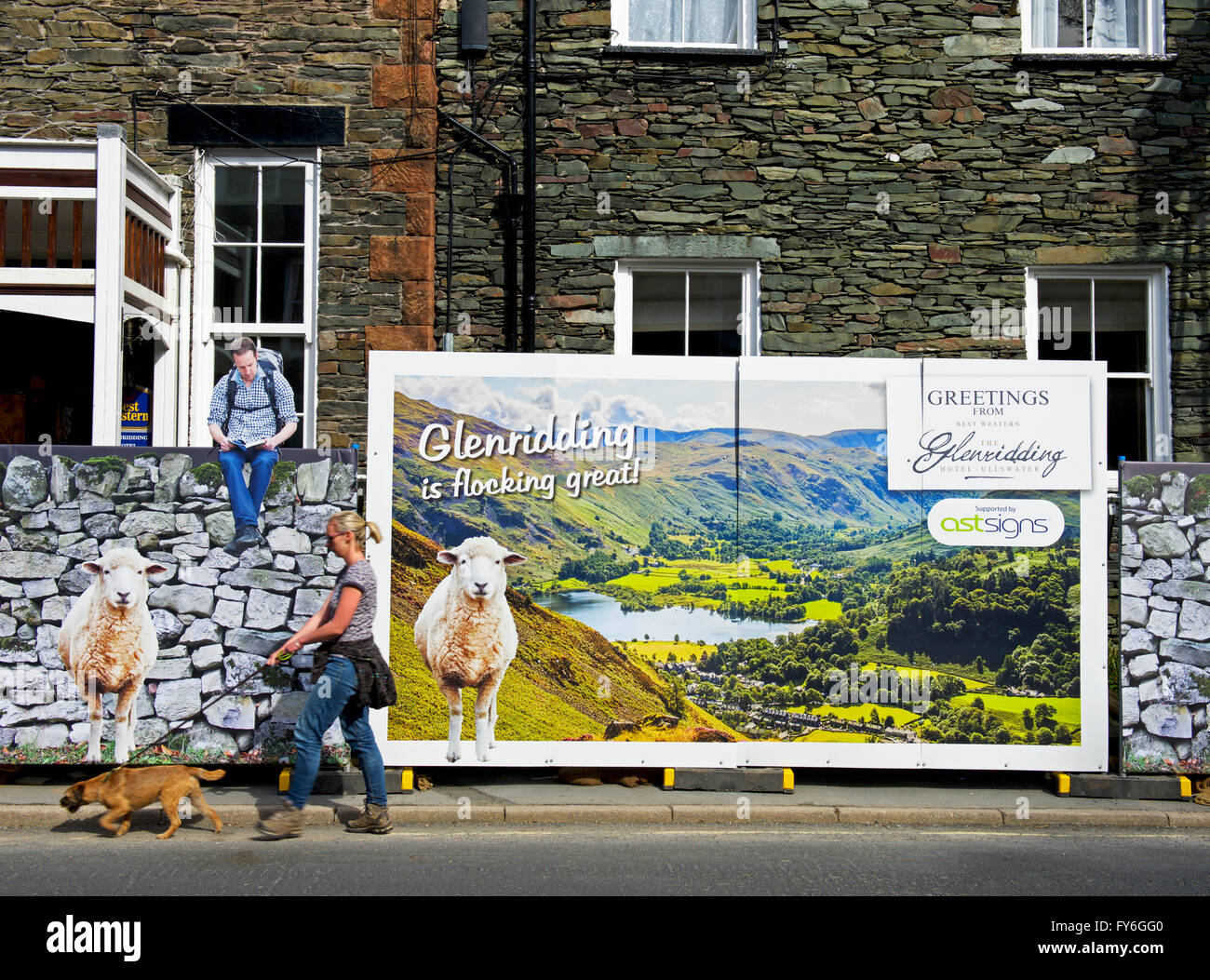Femme marche passé érigés en face de Royal Hotel, Shap, Parc National de Lake District, Cumbria, Angleterre, Royaume-Uni Banque D'Images