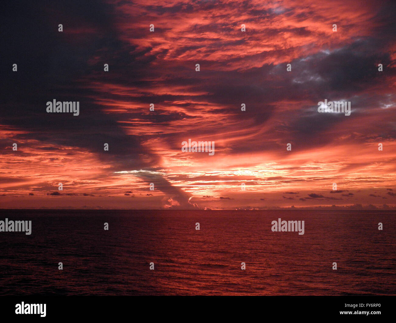 Feu rouge après le coucher du soleil sur l'océan pacifique à l'échelle avec cloud sauvages scape. Banque D'Images