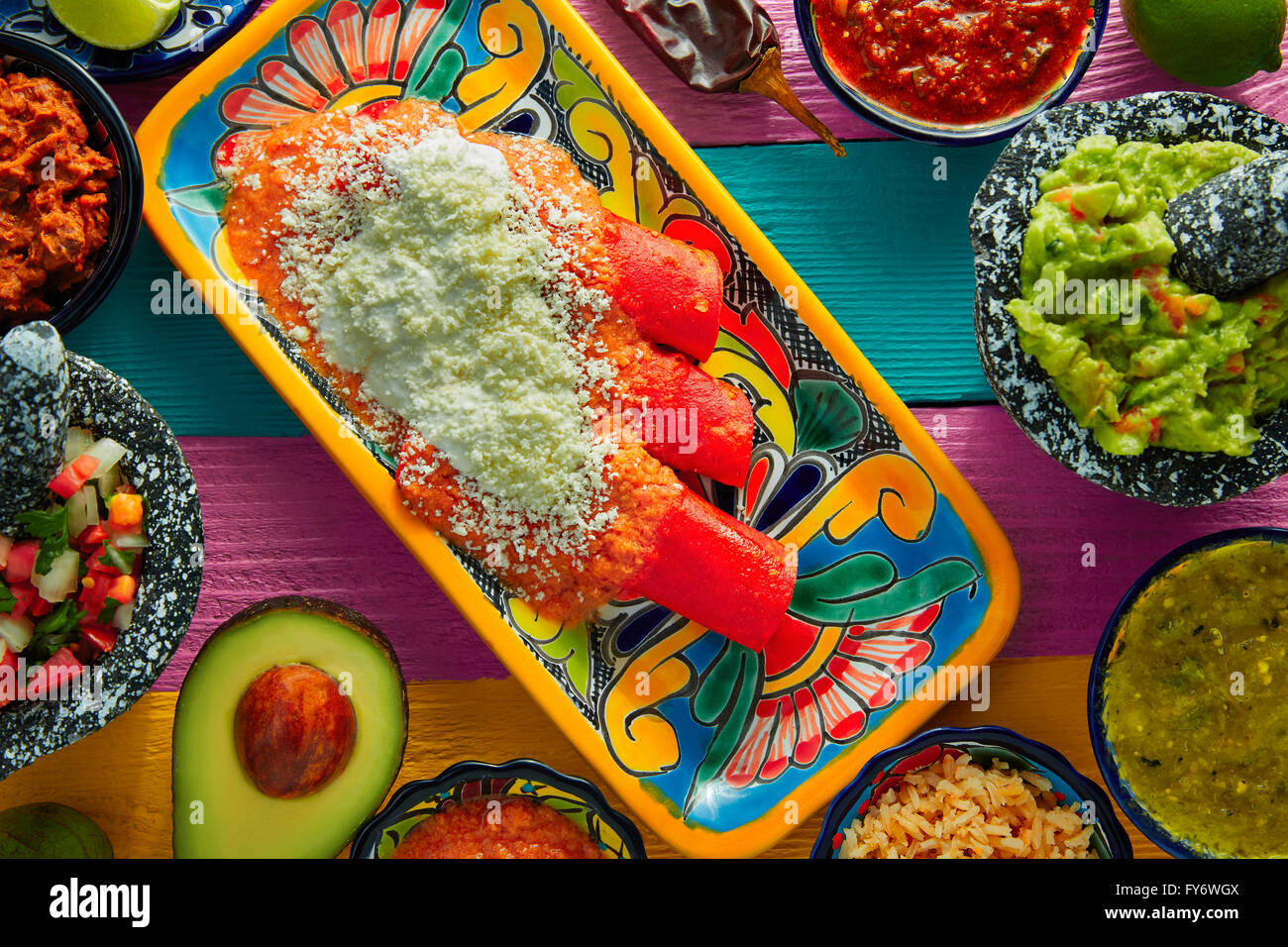 Cuisine mexicaine enchiladas rouge avec guacamole et sauces sur tableau coloré Banque D'Images