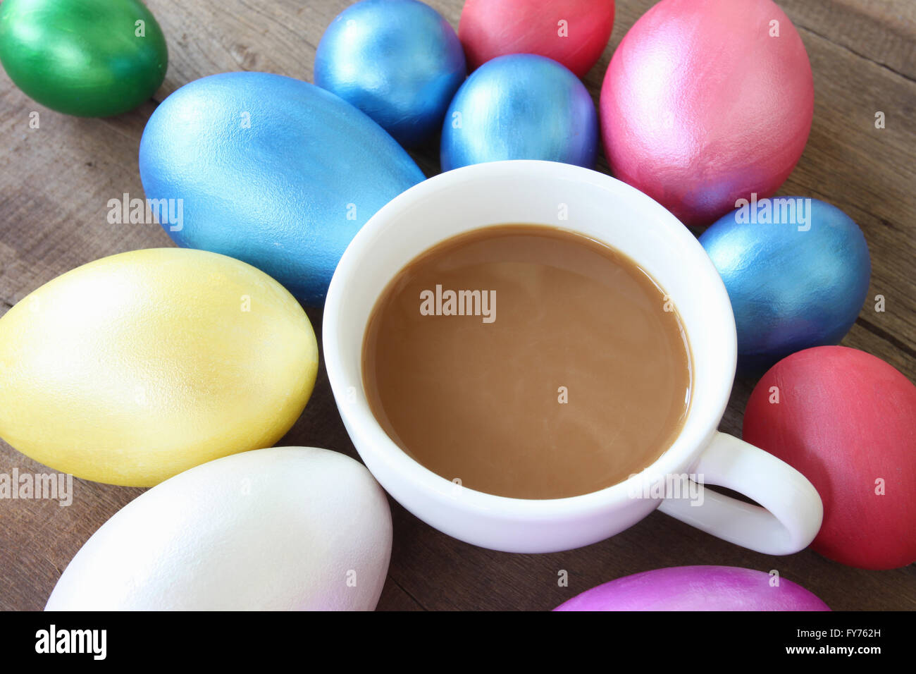 Les œufs de Pâques et du café tasse sur fond en bois peint à la main,pour la conception heureux jour de Pâques. Banque D'Images