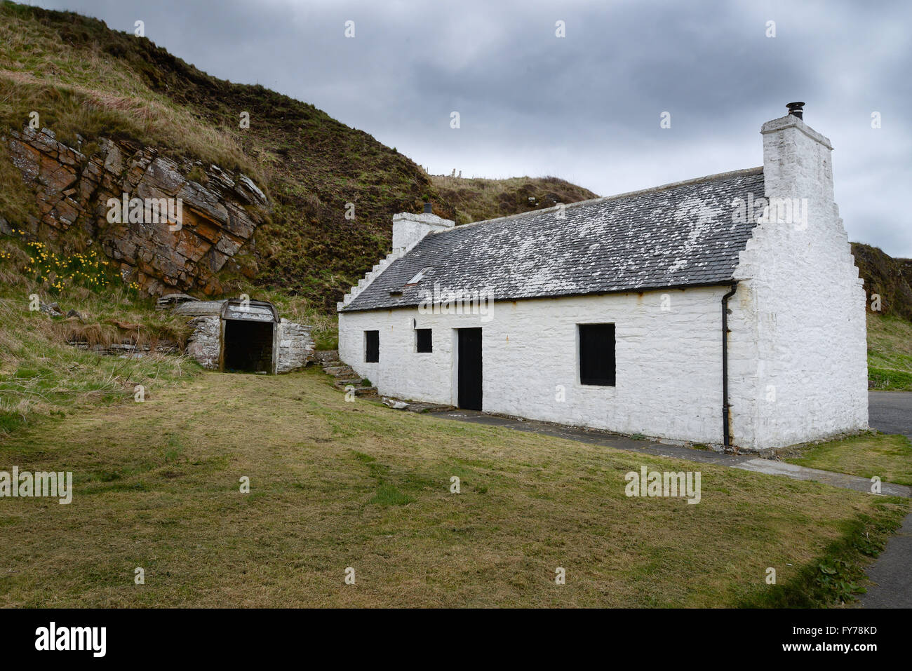 Dunbeath, saumon bothy avec un vieux bateau utilisé comme la toiture d'un magasin. Banque D'Images