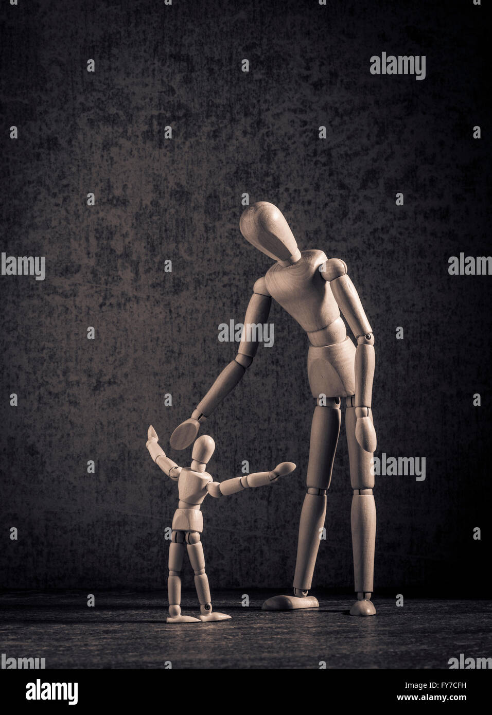 Figurines en bois, symbole de l'enfance, de la parentalité et montrant l'amour et l'affection comme parent seul avec un enfant. Banque D'Images