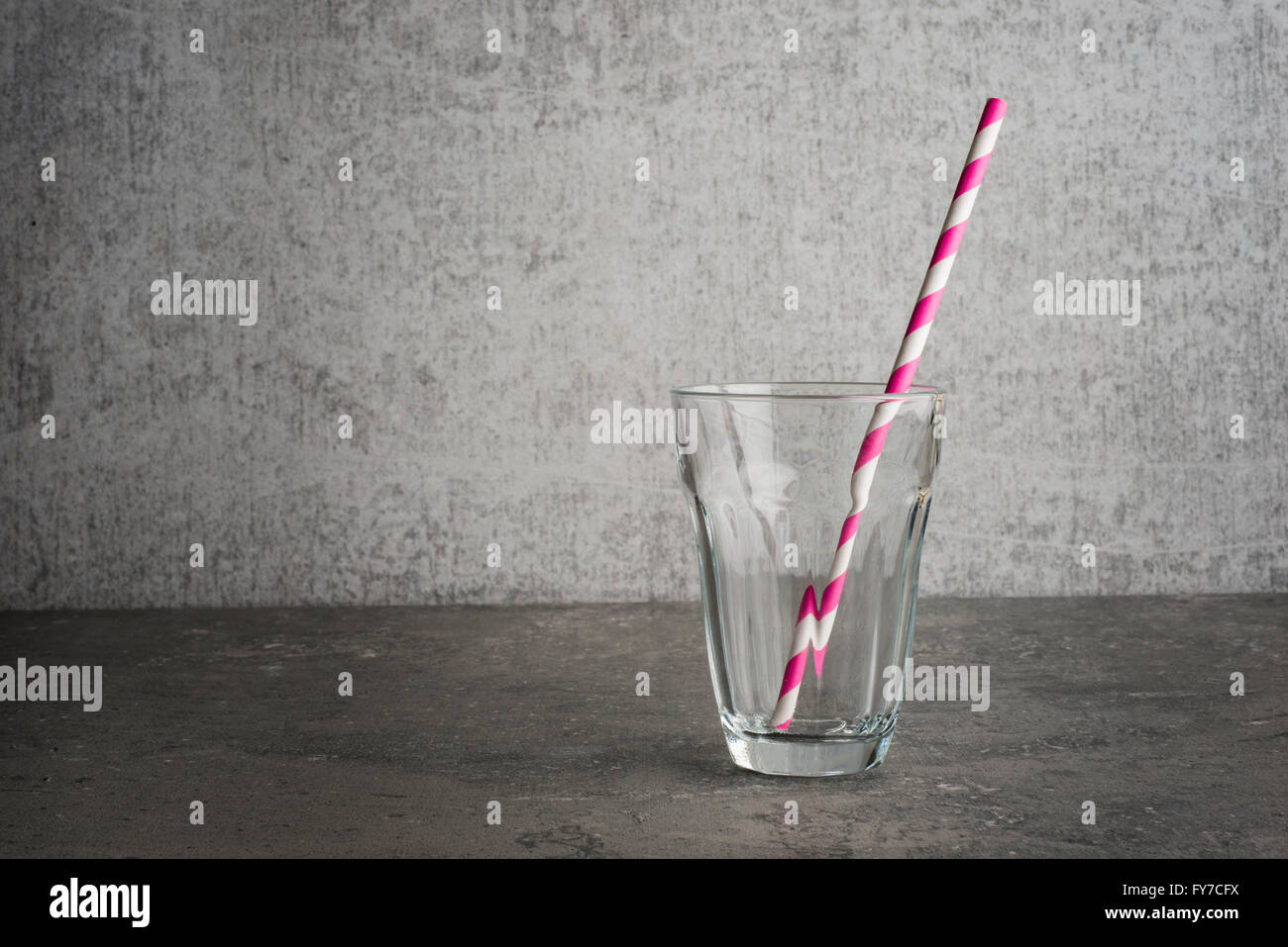 Verre vide avec paille studio still life la paille est le verre est rayé sur St pierre d'une copie de la table de l'espace sur le Banque D'Images