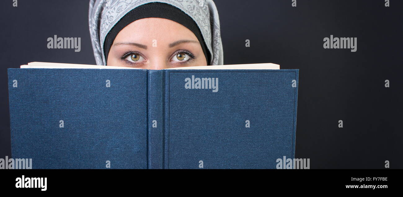 Jeune femme musulmane tenant un livre Banque D'Images