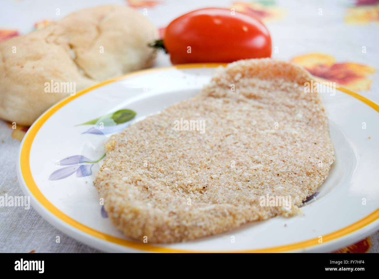 Escalope de veau non cuites avec un morceau de pain et tomates fraîches Banque D'Images