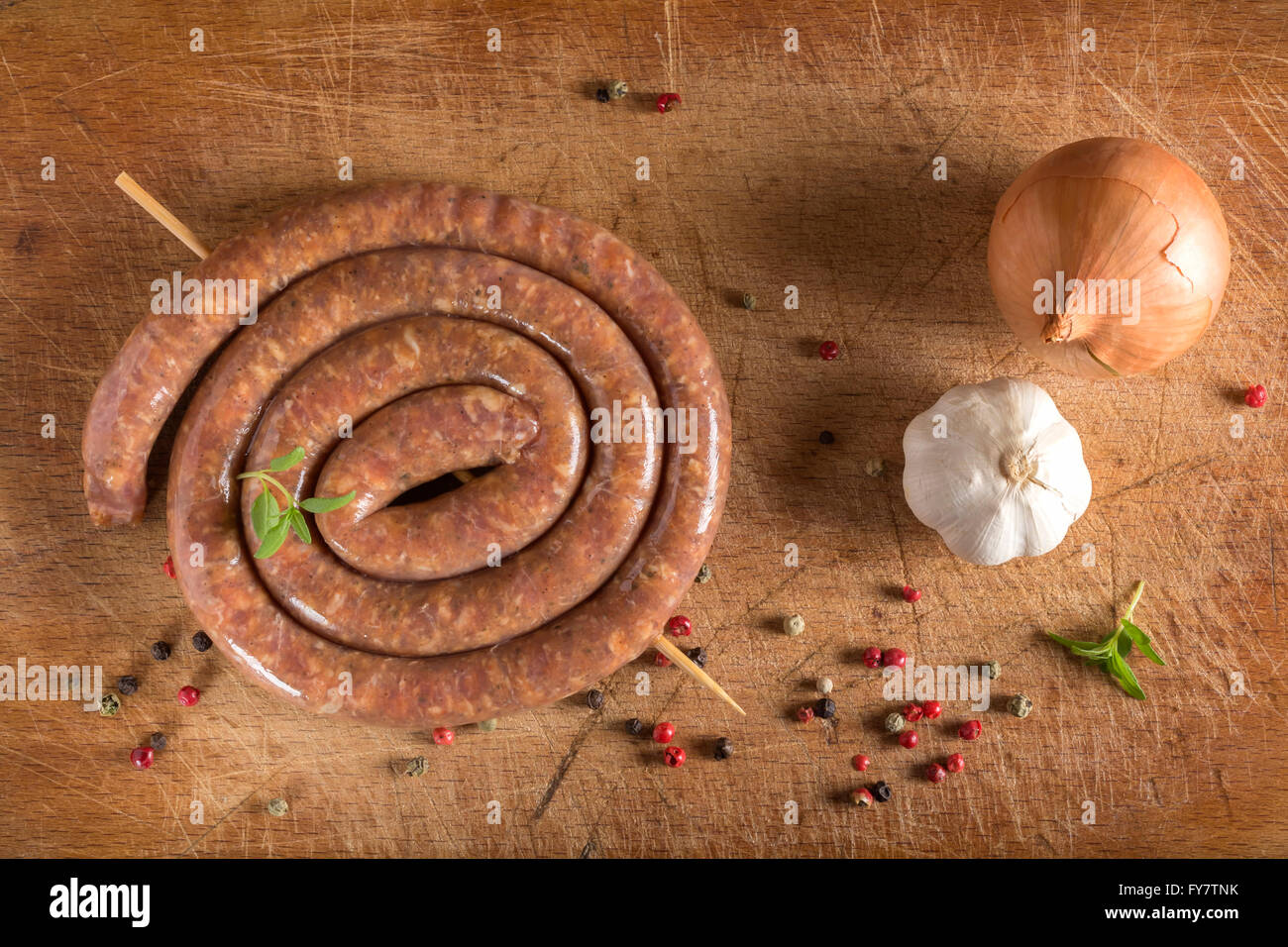 Saucisse crue sur planche à découper en bois Banque D'Images