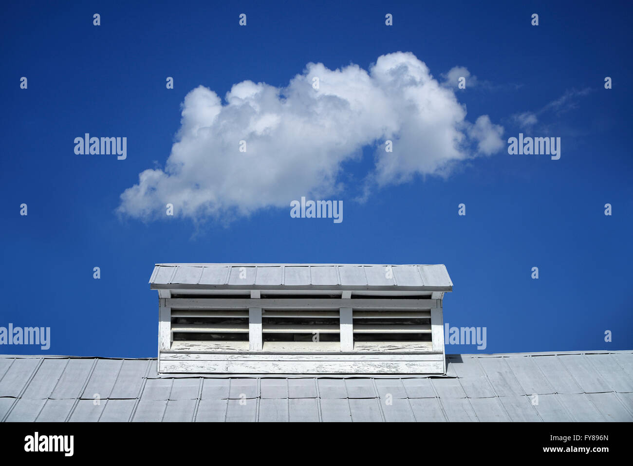 Seul nuage sur un toit de grange blanche sur Boon Hall Plantation à Charleston, Caroline du Sud Banque D'Images