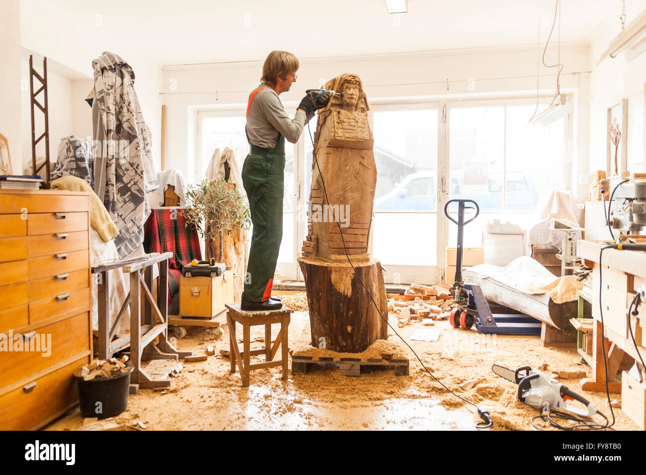 Sculpteur sur bois en atelier travaillant sur la sculpture avec fraiseuse,  debout sur la selle Photo Stock - Alamy