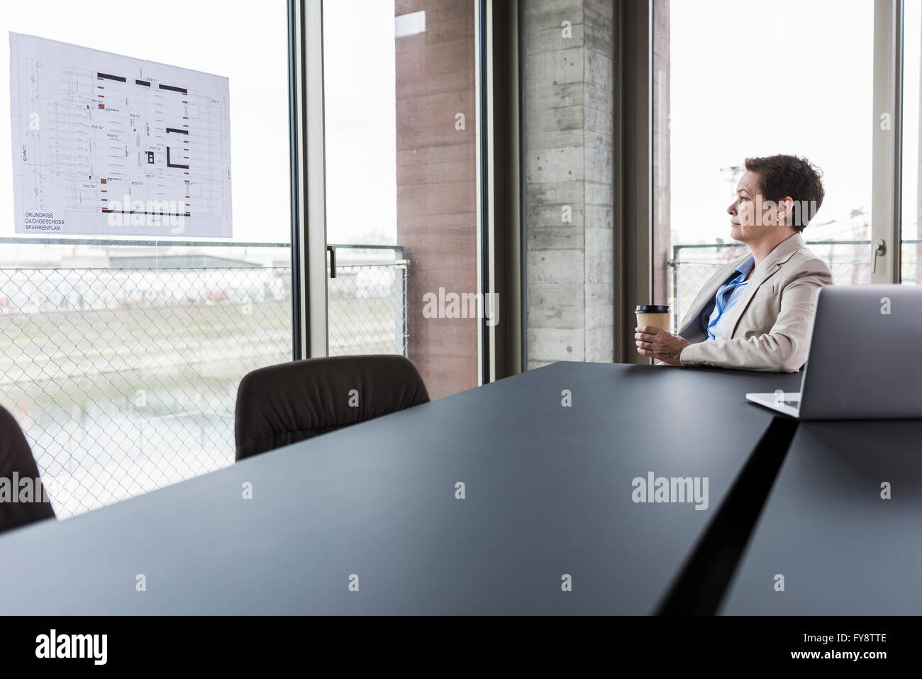 Businesswoman looking at construction plan dans la salle de conférence Banque D'Images