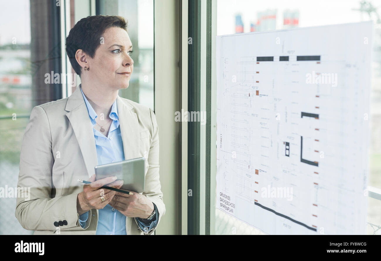 Couple à la fenêtre avec plan de construction Banque D'Images