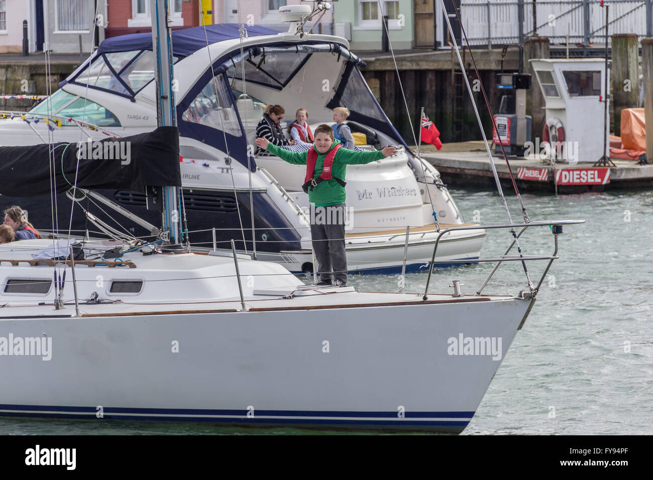 Weymouth, Angleterre. 23 avril 2016. 90e anniversaire de la reine hommage flottante. Garçon en vert sur le bateau. Credit : Frances Underwood/Alamy Live News Banque D'Images