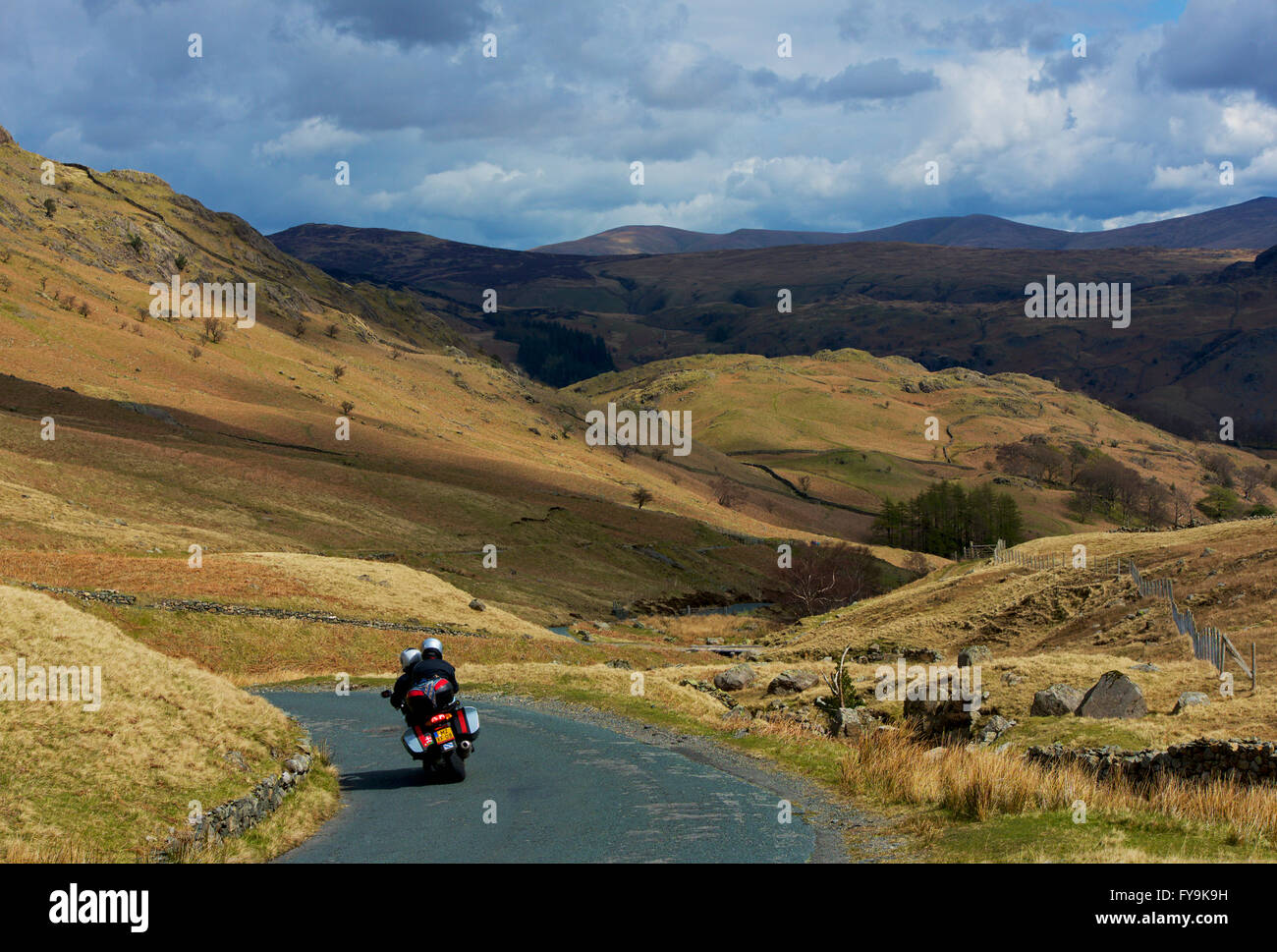 Couple en moto descendant le Col de Honister (B5289), parc national de Lake District, Cumbria, Angleterre Banque D'Images