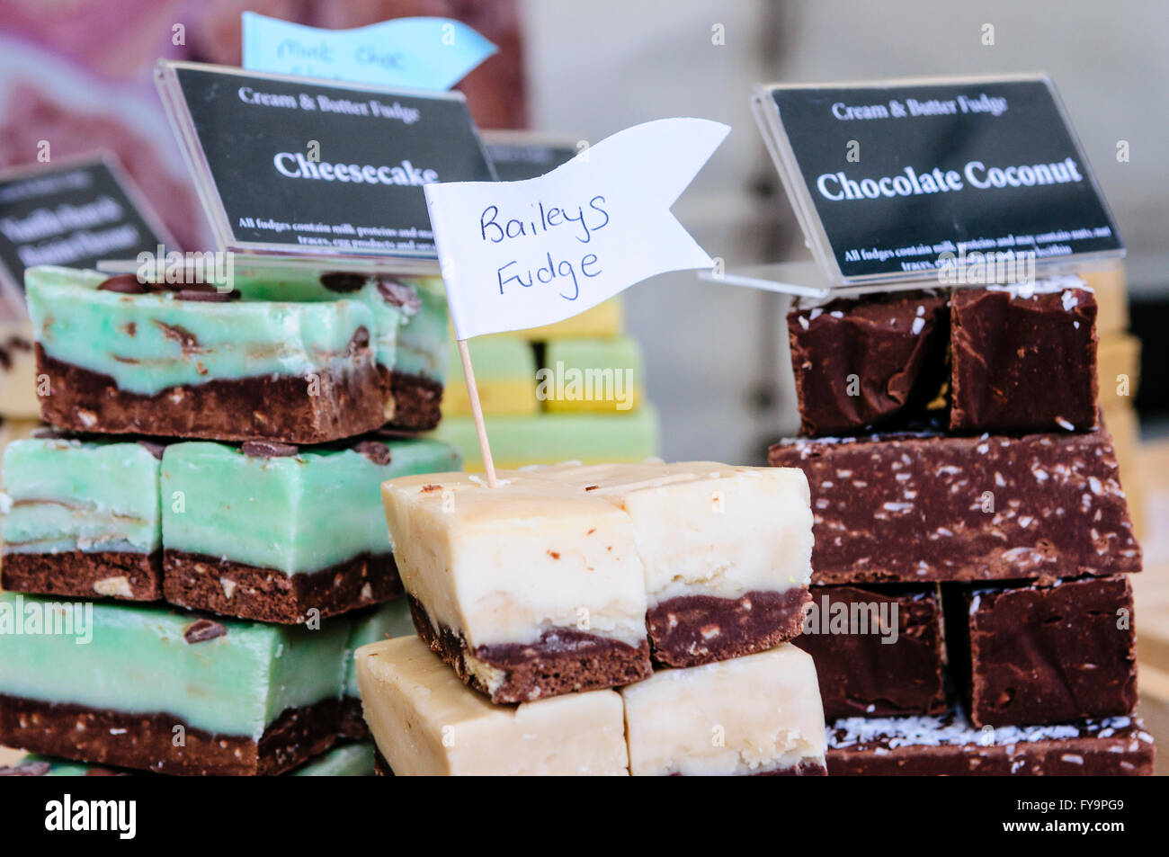 Divers en vente fudges at a market stall : Bailey's Irish Cream, Chocolat et noix de coco Gâteau au fromage. Banque D'Images