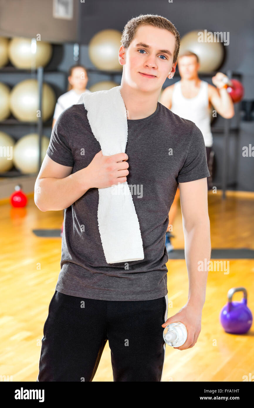 Confiant et smiling young man exercising at gym Banque D'Images