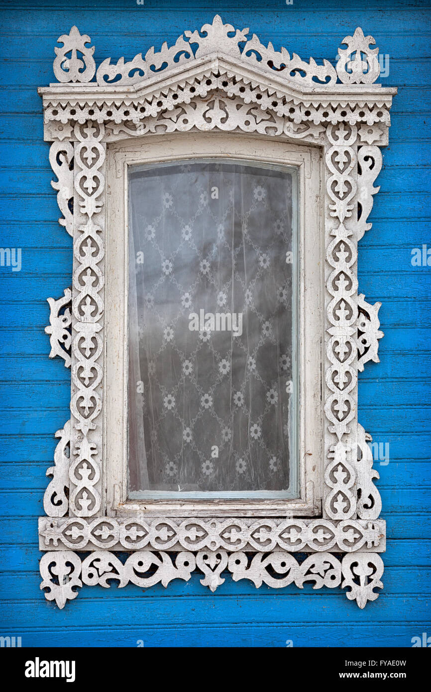Une belle photo de gros plan, de meubles anciens, de style russe avec fenêtre orné, cadre blanc, monté sur un mur bleu. Banque D'Images