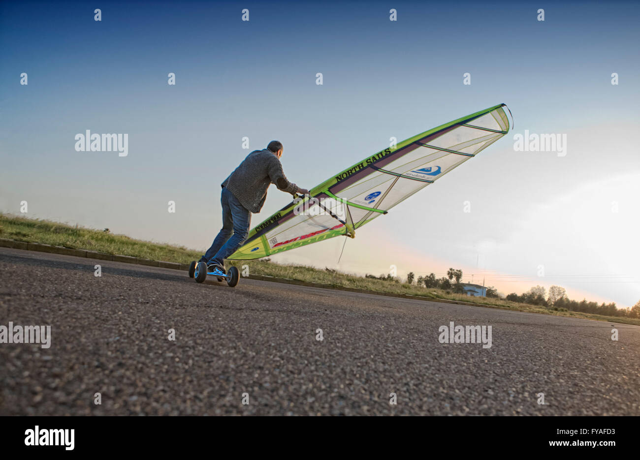 BADAJOZ, Espagne, le 27 mars. Un sportif équitation son skate par l'asphalte d'un parking du stade au coucher du soleil, le 27 mars 2012, Badajo Banque D'Images