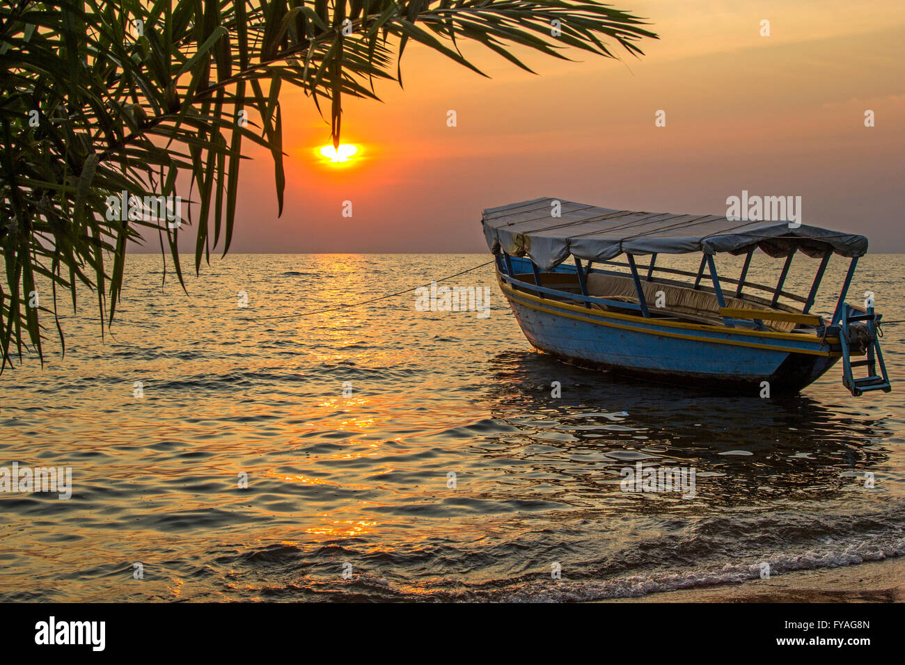 Belle vue sur bateau amarré sur les vagues contre de coucher du soleil en mer. Le lac Victoria, en Tanzanie Banque D'Images