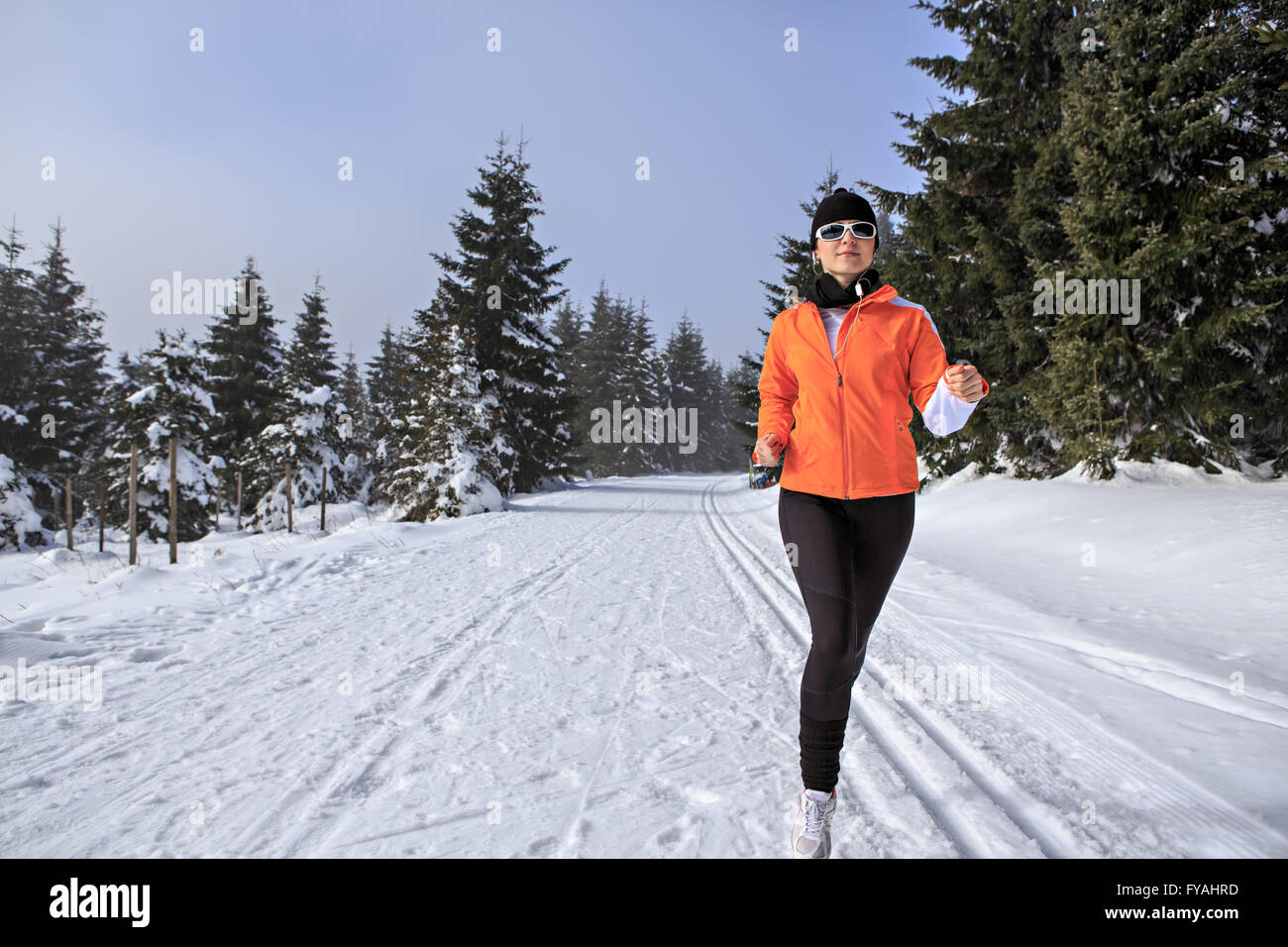 Une jeune femme le jogging dans la forêt d'hiver Banque D'Images