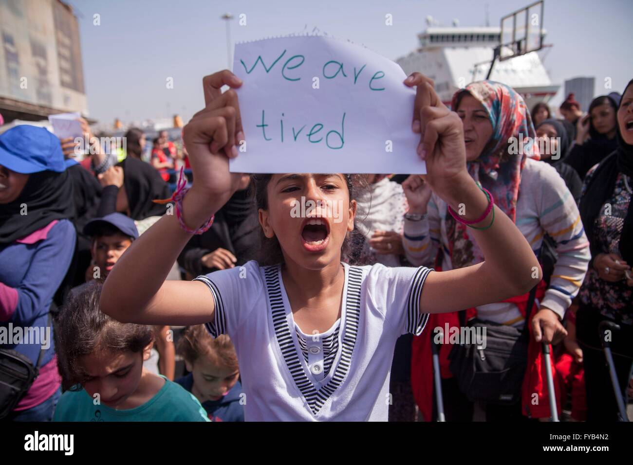 Fille de réfugiés afghans au port du Pirée. Fille afghane avec "Nous sommes fatigués". Les réfugiés restent pendant des semaines à habour et espérons poursuivre votre voyage vers l'Europe du Nord. 08.04.2016 Banque D'Images