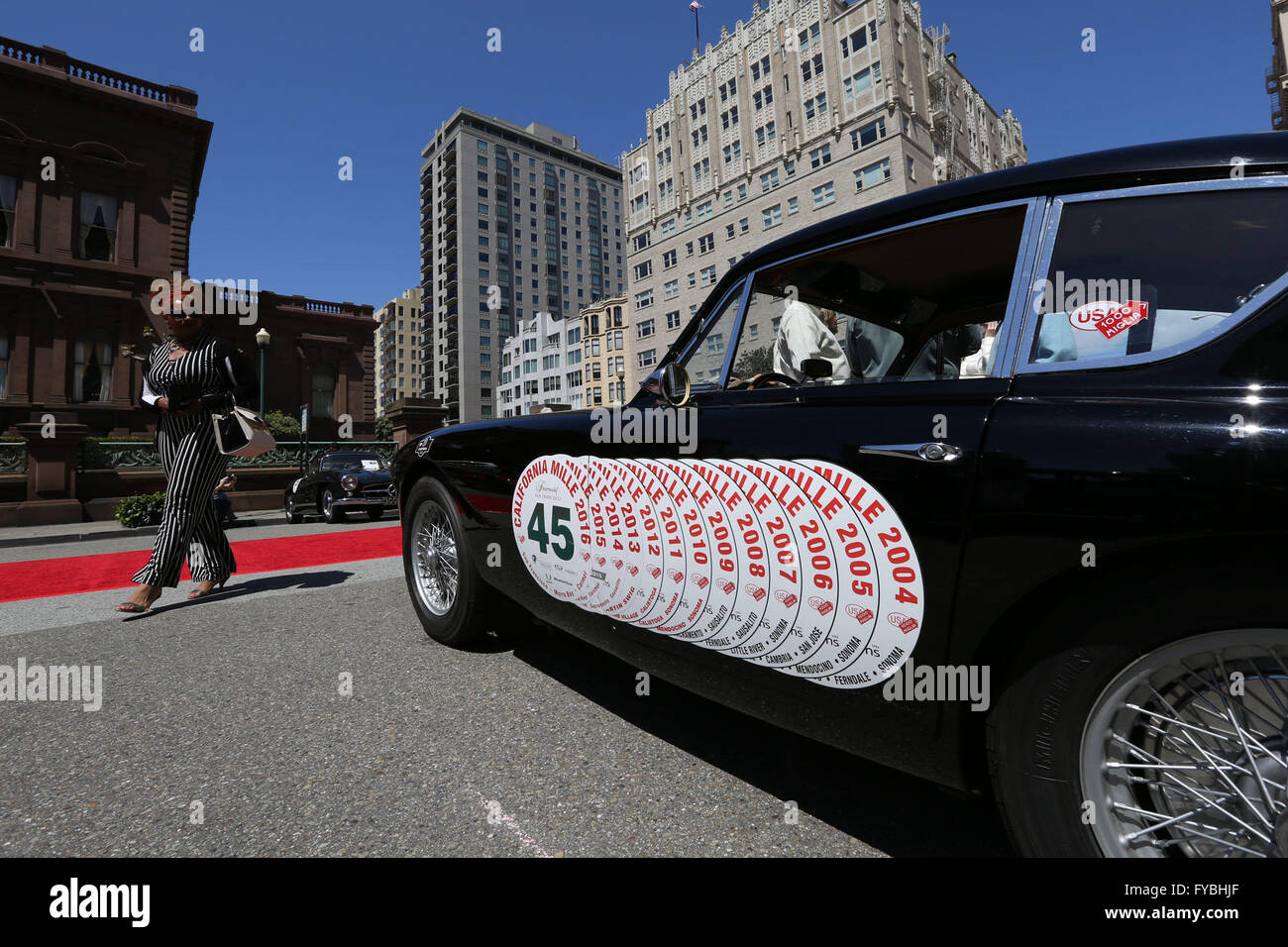 San Francisco, USA. 25 avril, 2016. Une femme passe devant une voiture historique qui a participé en Californie pour 13 mille fois en face de l'hôtel Fairmont de San Francisco, États-Unis, le 24 avril 2016. Soixante-sept véhicules historiques à partir d'une douzaine d'États américains ainsi que l'Allemagne et la Colombie ont été affichés en face du Fairmont Hotel de San Francisco le dimanche. © Xinhua/Alamy Live News Banque D'Images