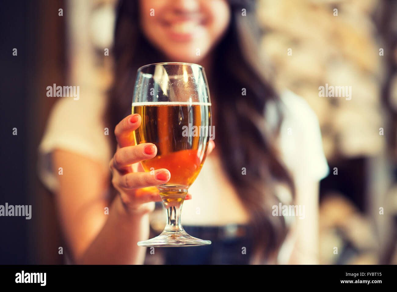 Happy woman holding glass of projet de bière blonde Banque D'Images
