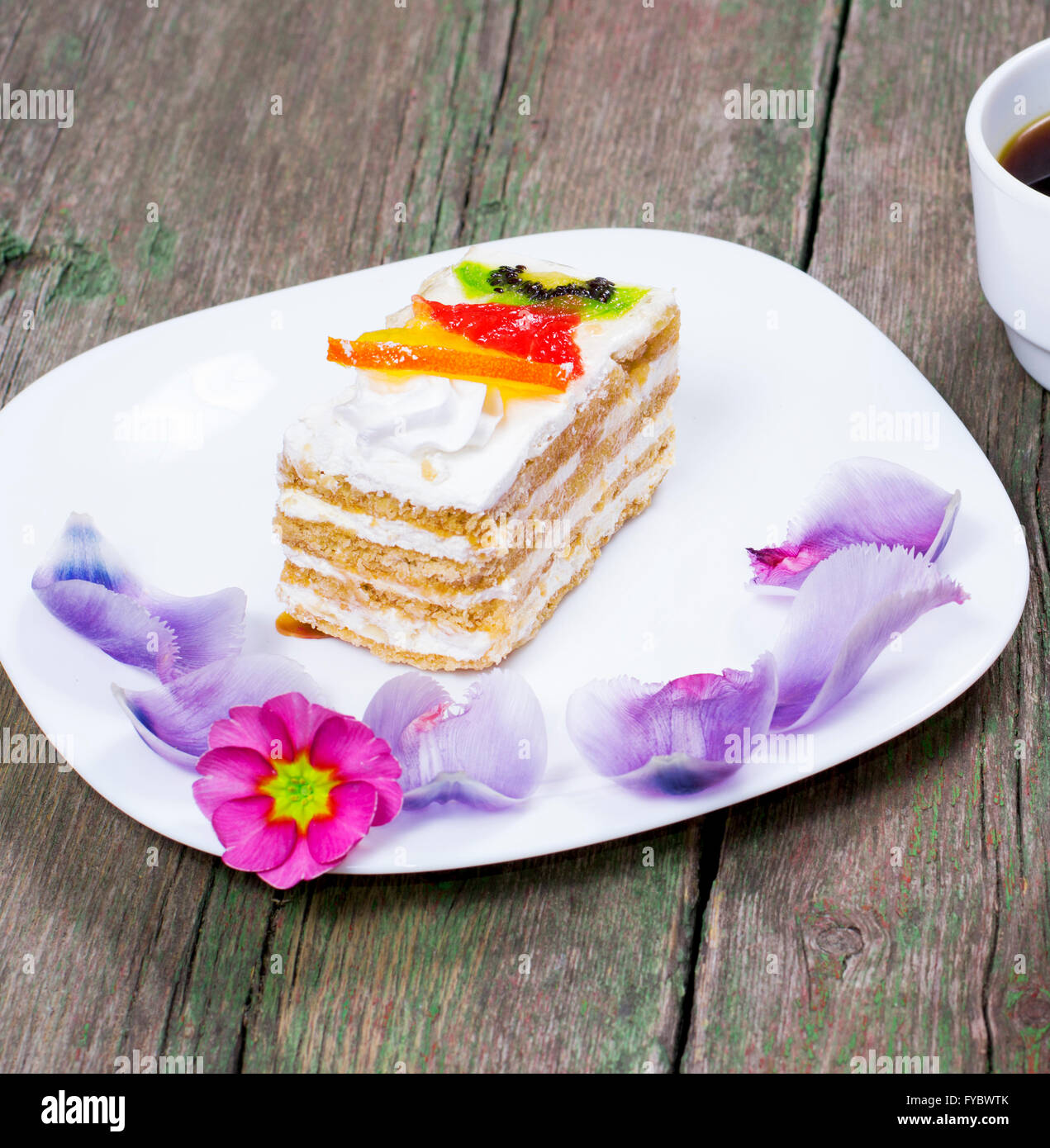 Le gâteau de fruit sur une assiette blanche décorée de fleurs Banque D'Images